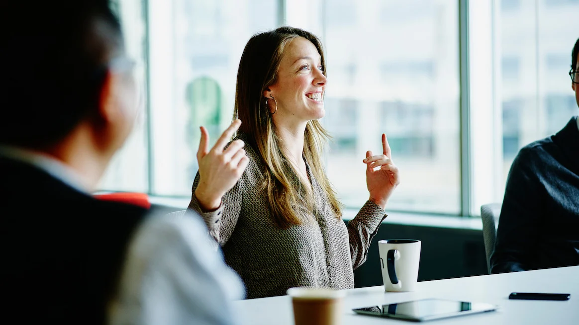 motivating-a-team-woman-at-meeting-smiling